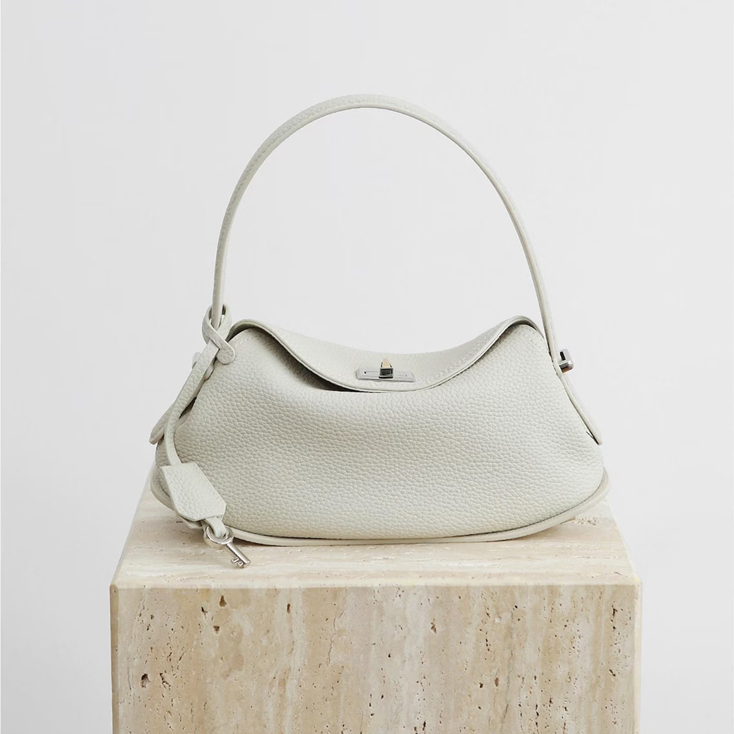 Triple-Tone Pebbled Curved Saddle Handbag With Arched Single Carry Loop, Metallic Turn-Lock Flap And Side Fabric Tab Detail